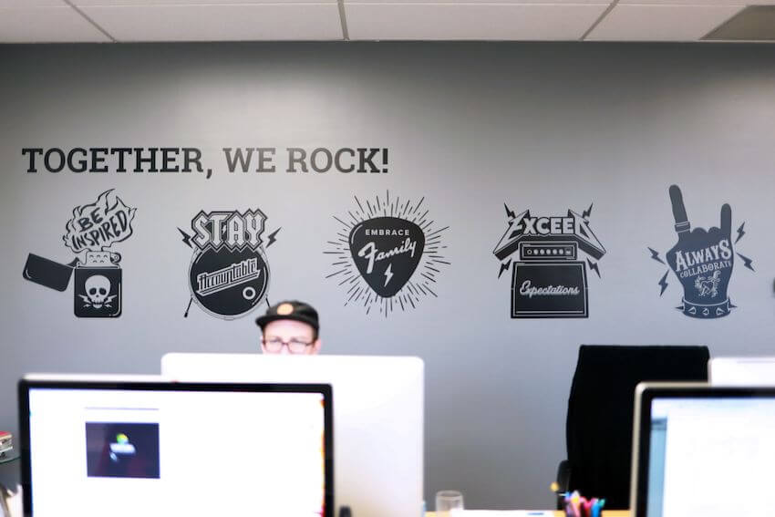 together we rock core values behind employees at computers